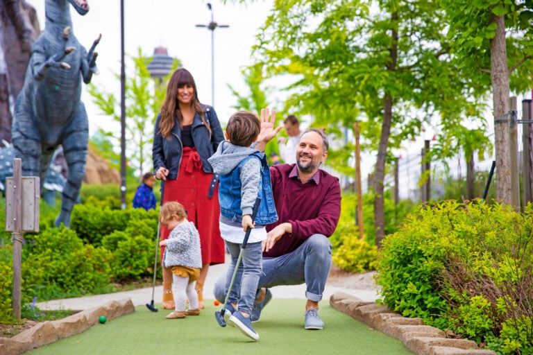 Family Mini Putting Near Large Dinosaurs